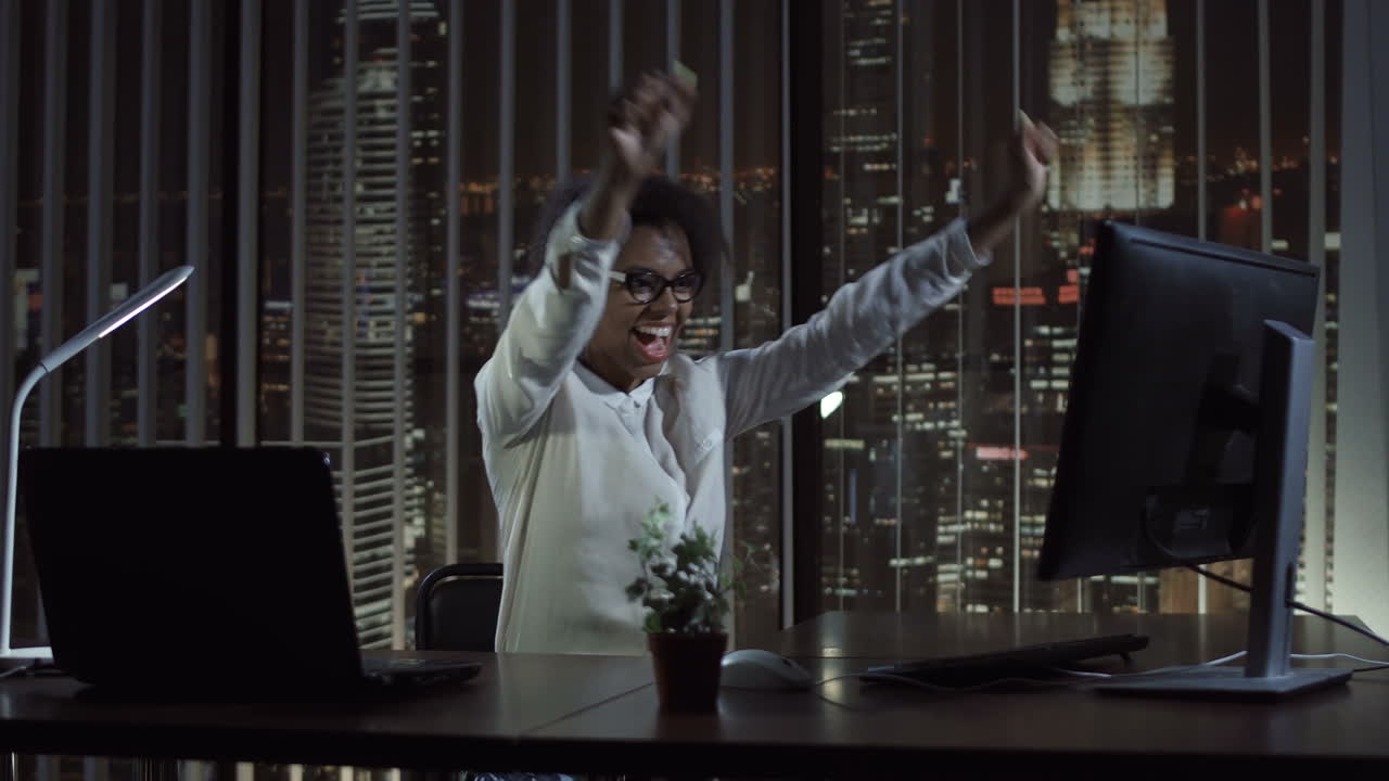 Professional Woman Celebrating Success in a Night Office