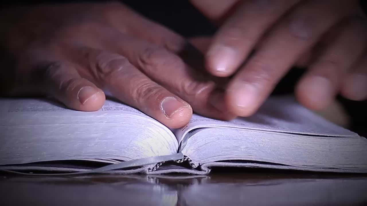 manos rezando sobre una biblia con vídeos de stock de personas