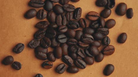 Vintage-look-of-coffee-beans-on-old-paper-rotating-4K-close-up-video-from-top