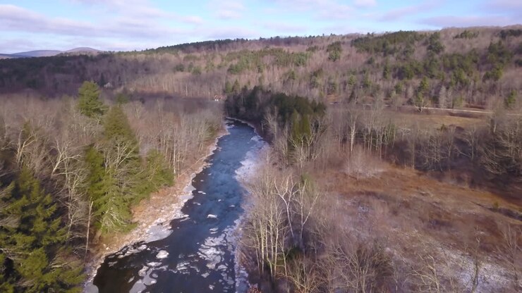 Riprese aeree con drone che si avvicinano a una baita invernale su un fiume nello stato di New York settentrionale.