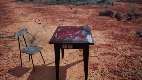 abandoned table and chair in a desert landscape