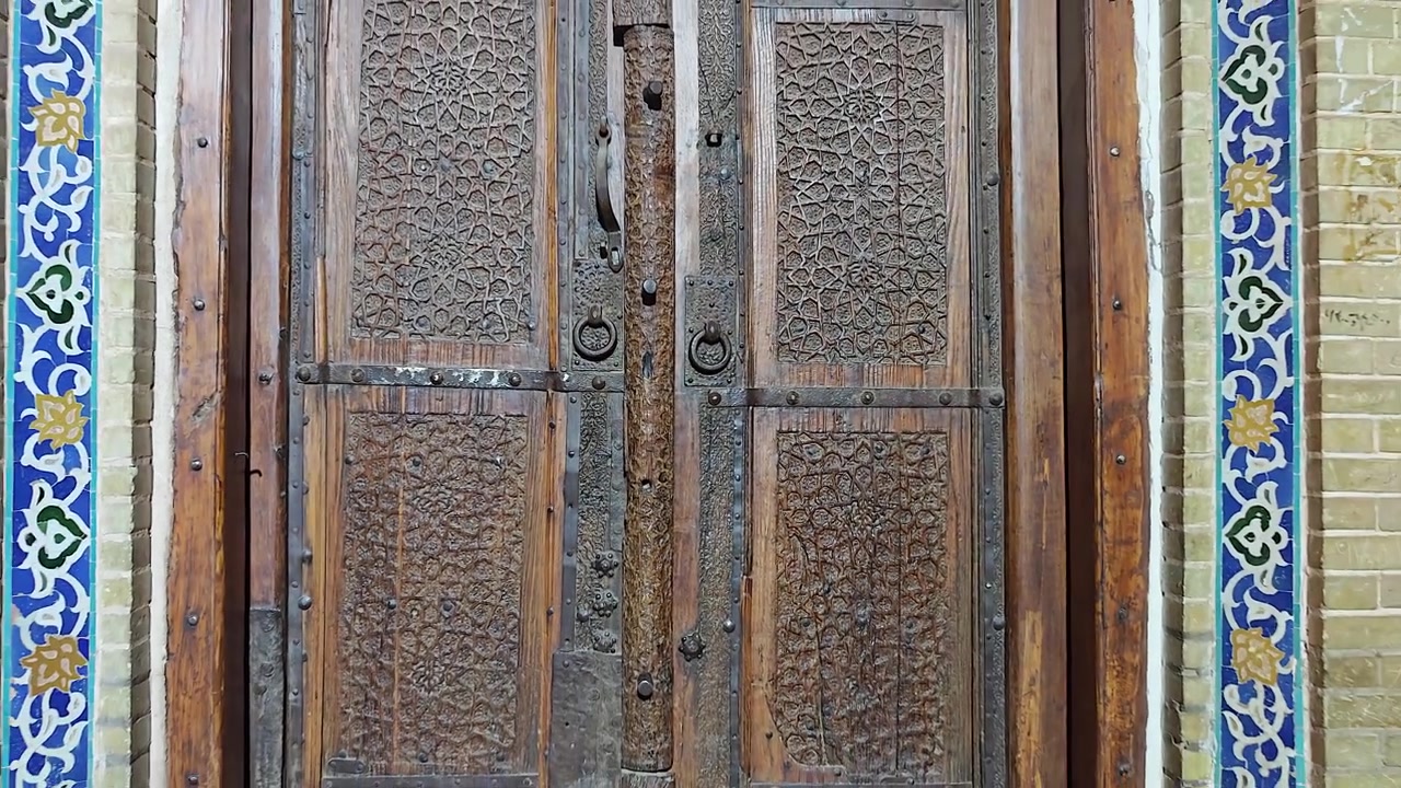 Karmaşık oymalar ve metal detaylara sahip süslü antika ahşap kapı.