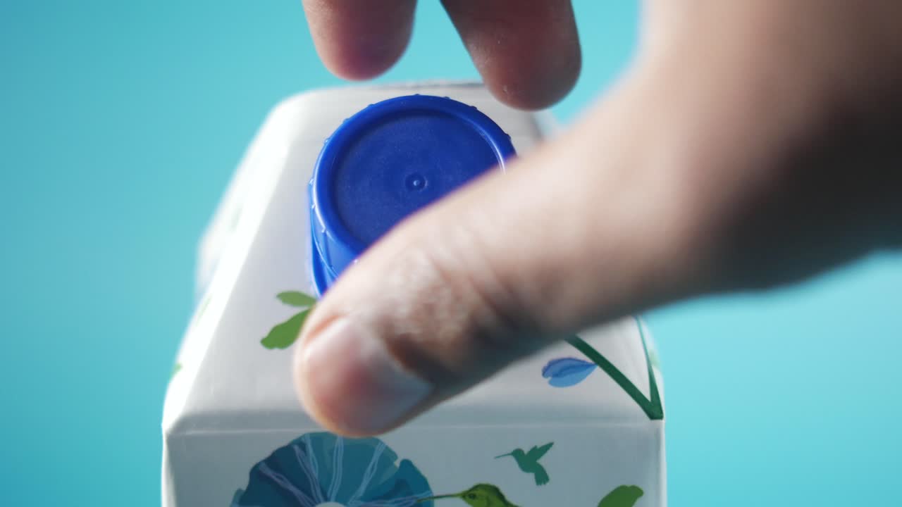 주스 상자를 열고 있는 손