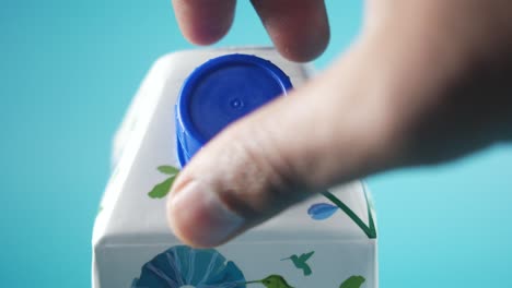 mano abriendo una caja de jugo