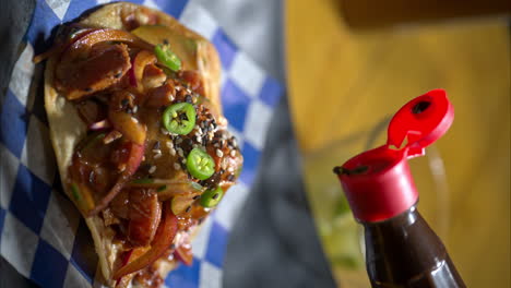 Slow-motion-close-up-of-a-red-hot-mexican-salsa-being-poured-on-top-of-a-seafood-tostada-with-green-chilli