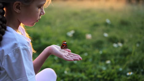 girl with butterfly in hand at sunset