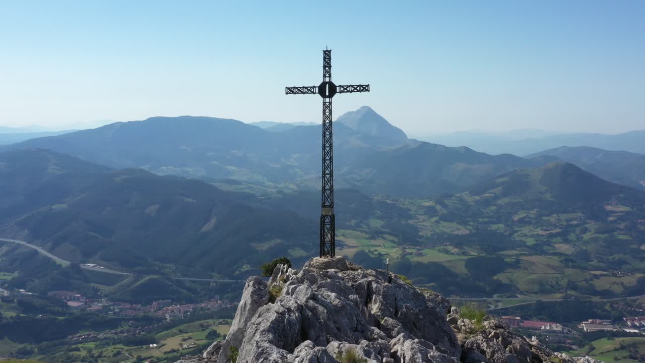 vista aérea de drones de una gran cruz de hierro en la cima de una montaña en el país vasco