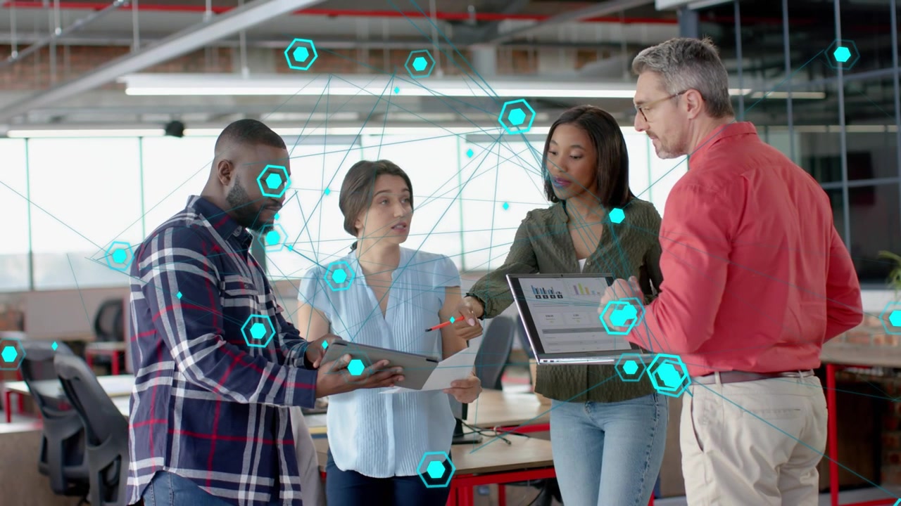 Team gathering around tablet, left man tilting it, initiating network overlay guiding tech analysis