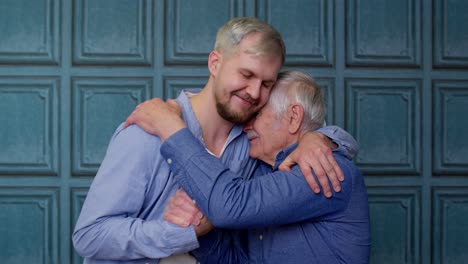 Cheerful-excited-young-man-embracing-gray-haired-old-dad-or-grandfather,-male-generations-family