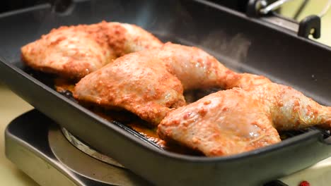 turning peri-peri chicken while grilling in the pan