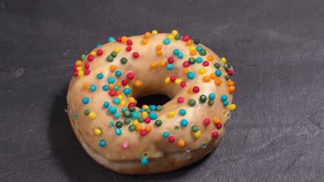 el donut dulce gira sobre un fondo oscuro. la dulzura tradicional estadounidense