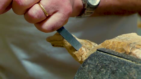 italian sculptor in his workshop working on a olive wood statue