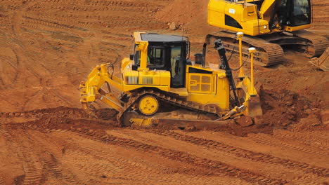 yellow crawler bulldozer mining sand at quarry. heavy machinery mining