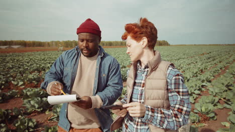 multiethnic coworkers discussing plans on farm field