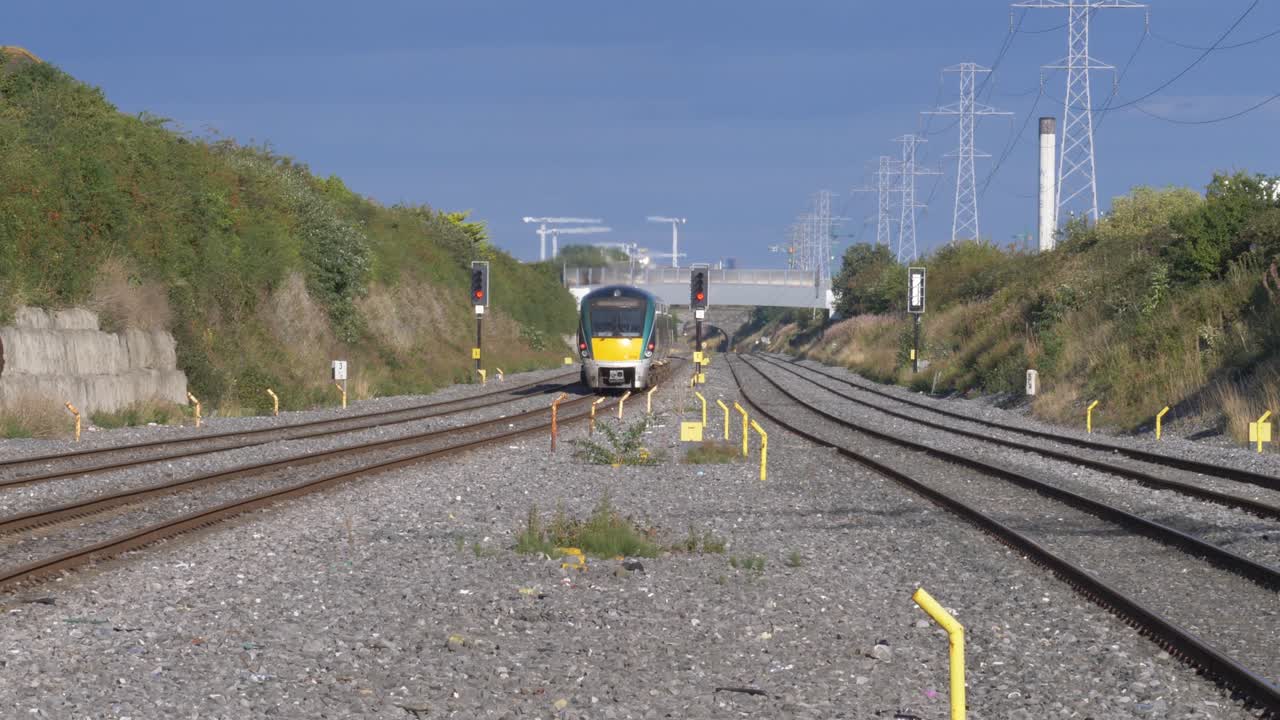 tren ferroviario irlandés acercándose al paso elevado del ferrocarril en el camino a la ciudad de dublín, irlanda durante el día