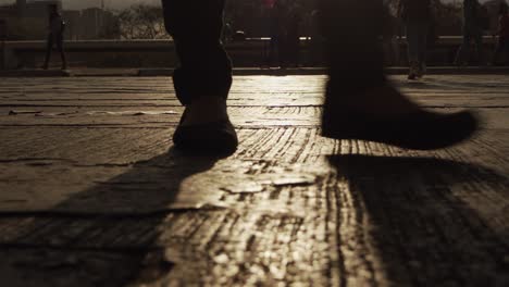 a man walks across the street during sunset with the light reflecting off the pavement