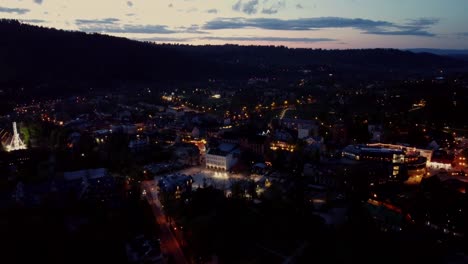 Night-time-flyover-of-Zakopane,-Poland,-a-resort-town-against-the-Tatra-Mountains,-and-its-stunning-Goral-traditional-architecture-2