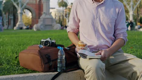 man eating a snack in the park