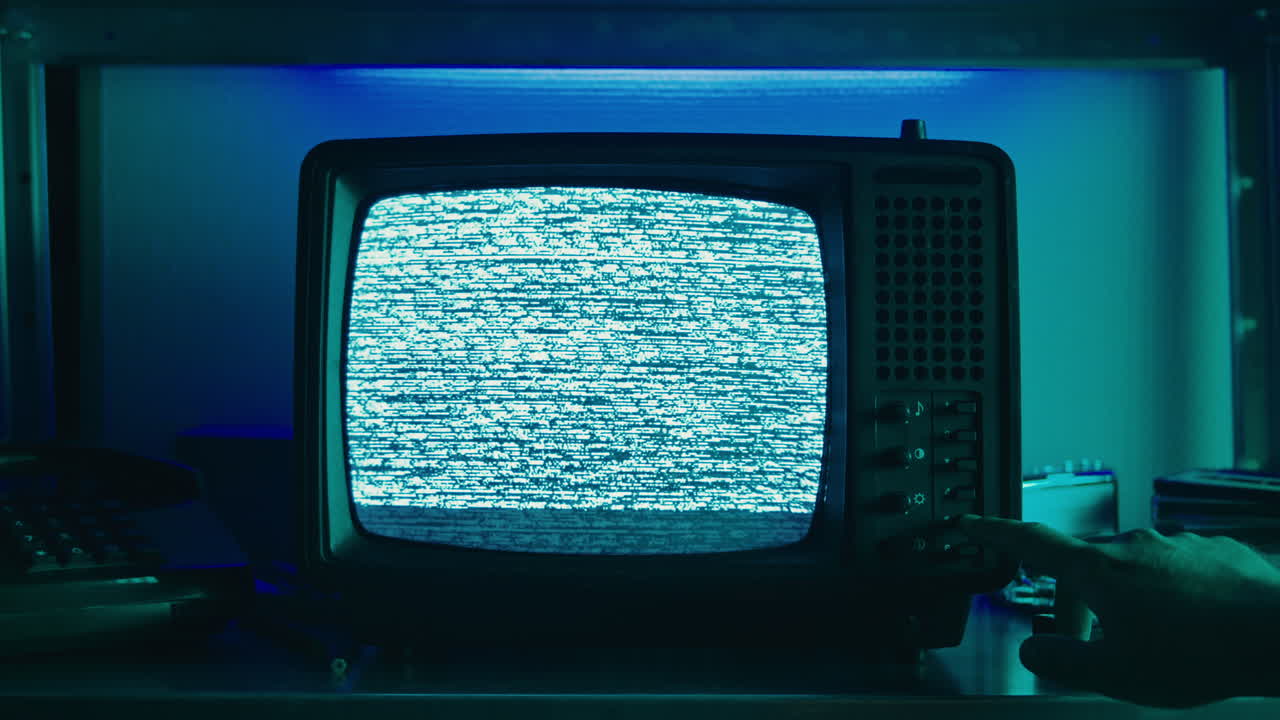 A retro TV displaying static noise, creating a nostalgic vintage atmosphere with blue and green hues.