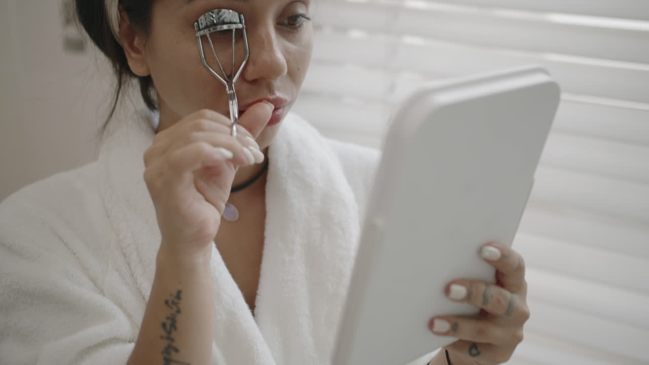 Caucasian Woman Using Eyelash Curler