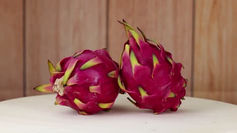 dragon fruits rotating on a wooden surface