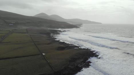 aerial: rugged coastline in north europe with big waves hitting cliffs