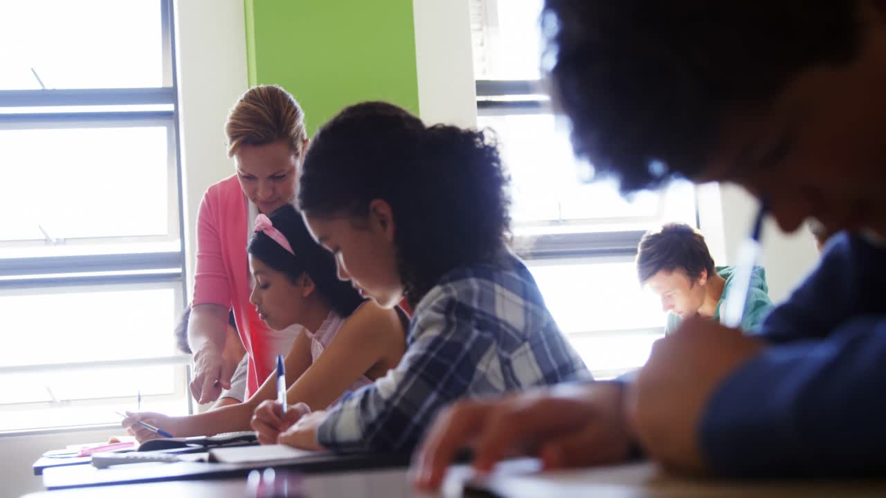 maestro ayudando a los estudiantes con sus tareas en el aula