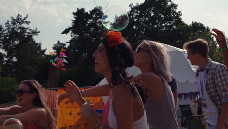 friends enjoying bubbles at a music festival, slow motion