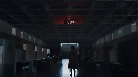 lonely girl silhouette walking dark corridor to stairway. pupil passing students