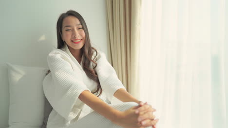 Cute-asian-girl-in-bathrobe-smiling-to-the-camera