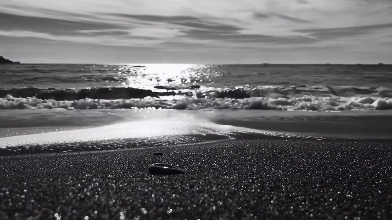 Pemandangan Hitam Putih Ombak Laut Bergulir ke Pantai Berpasir