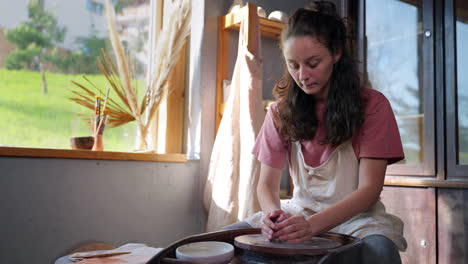 mujer trabajando en la rueda de cerámica