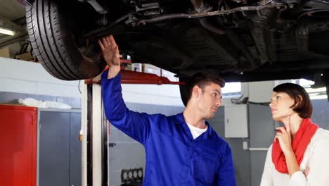 mechanic showing customer the problem with car