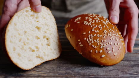 hands holding a sliced sesame seed bun