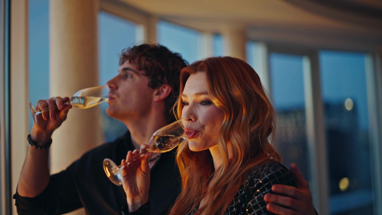 Coppia romantica che brinda con champagne in appartamento di lusso. Uomo che abbraccia donna di notte