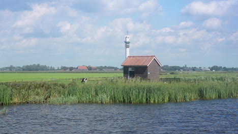 flat dutch landscape with telecommunication tower near the horizon, moving camera