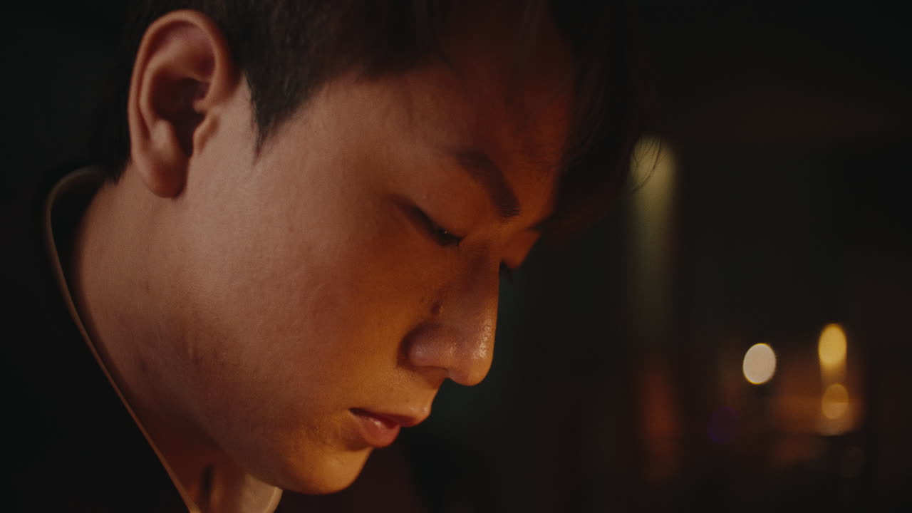 Close-up portrait of a young man in a dimly lit room