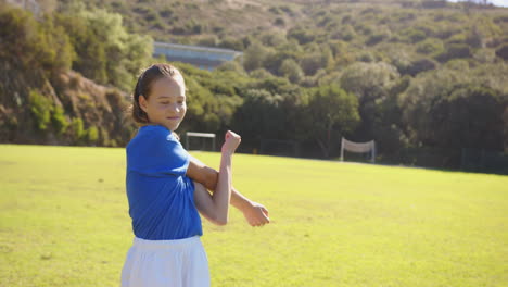 in school field, girl in sports uniform warming up, preparing for activity, copy space