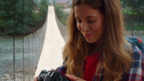 una chica sonriente disfruta fotografiando la hermosa naturaleza. una mujer revisa las fotos de la cámara.