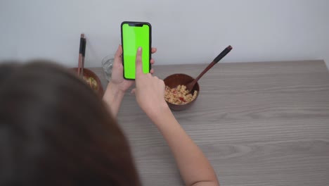person eating and using phone with green screen