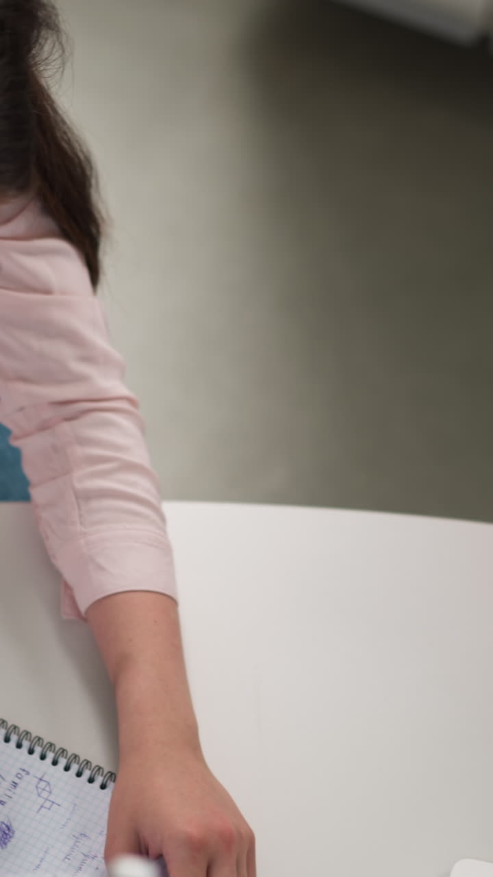 los compañeros de clase hacen los deberes usando diferentes fuentes. los estudiantes escriben datos de búsqueda en internet y estudian libros en el salón público. proceso de educación en la universidad