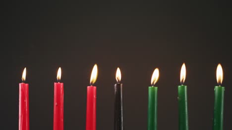 Composition-of-halloween-green,-black-and-red-lit-candles-against-black-background