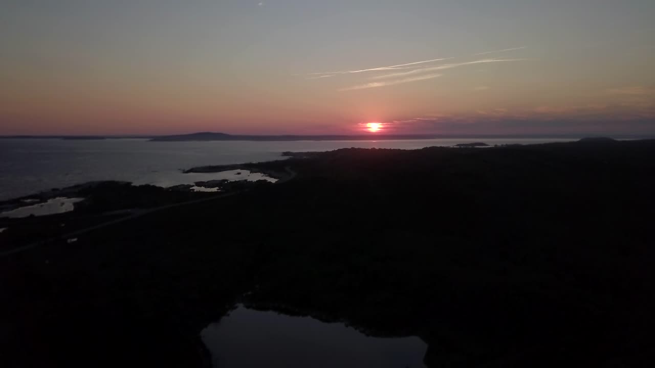 drone volando lentamente hacia la puesta de sol y el horizonte sobre el océano atlántico en nueva escocia en canadá