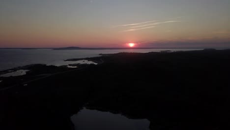 drone slowly flying up facing sunset and horizon over the atlantic ocean in nova scotia in canada