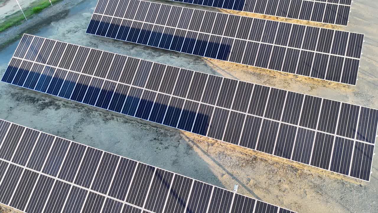 Drone footage captures solar panels. Bright lighting and steady camera movement highlight the renewable energy setup