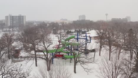 Aerial,-empty-snow-covered-water-slide-park-during-winter