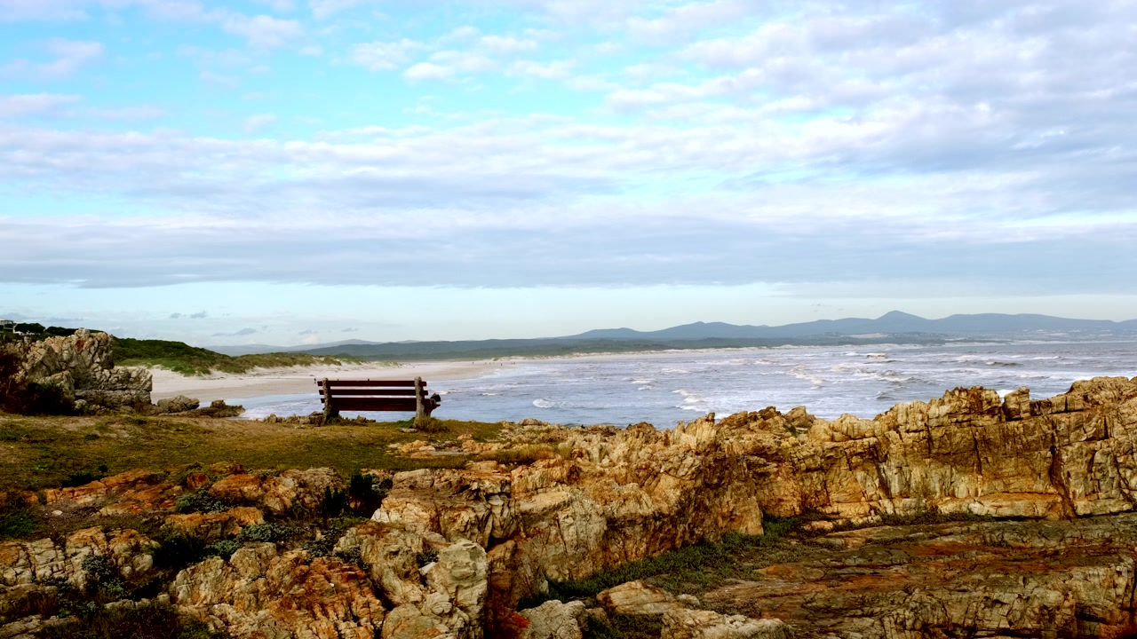 Bench with view of waves crashing onto Grotto Blue Flag beach Hermanus