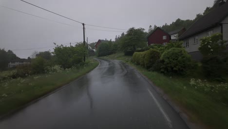 pov from a moving car driving on the wet road on a rainy day in norway