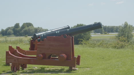 wide shot of old cannons overlooking typical dutch landscape