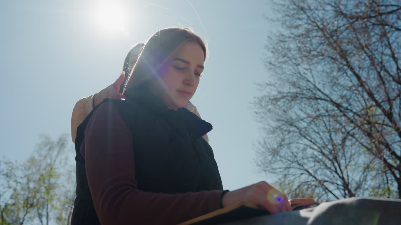 햇살 좋은 나뭇가지 아래에서 노트북을 보는 여성, 자연광이 비치는 환경에서 생각에 잠긴 듯한 여성 연구원, 밝은 햇살 아래 야외에서 조용히 책을 읽으며 사색에 잠긴 여성